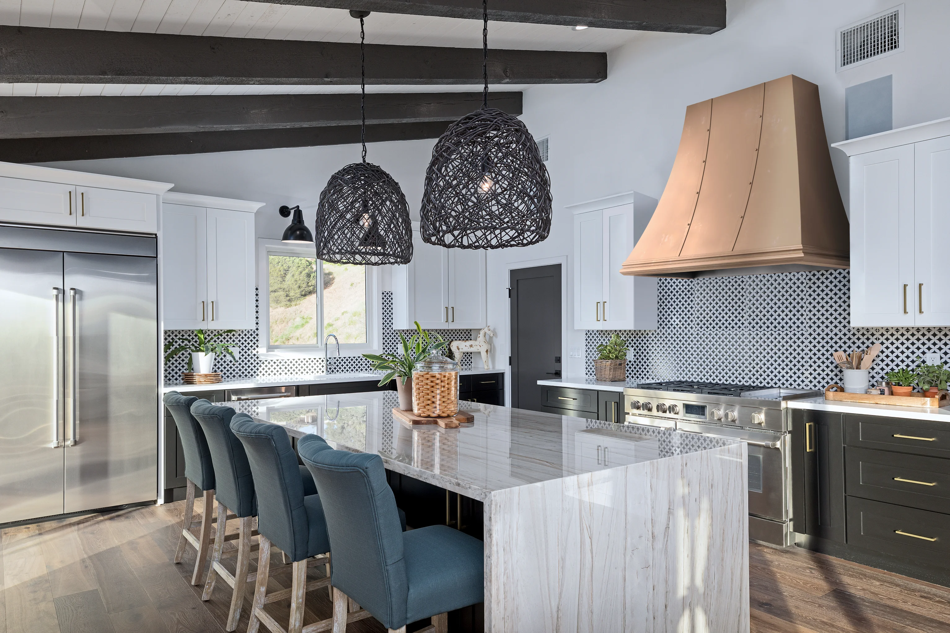 Kitchen with a copper range hood and a marble island