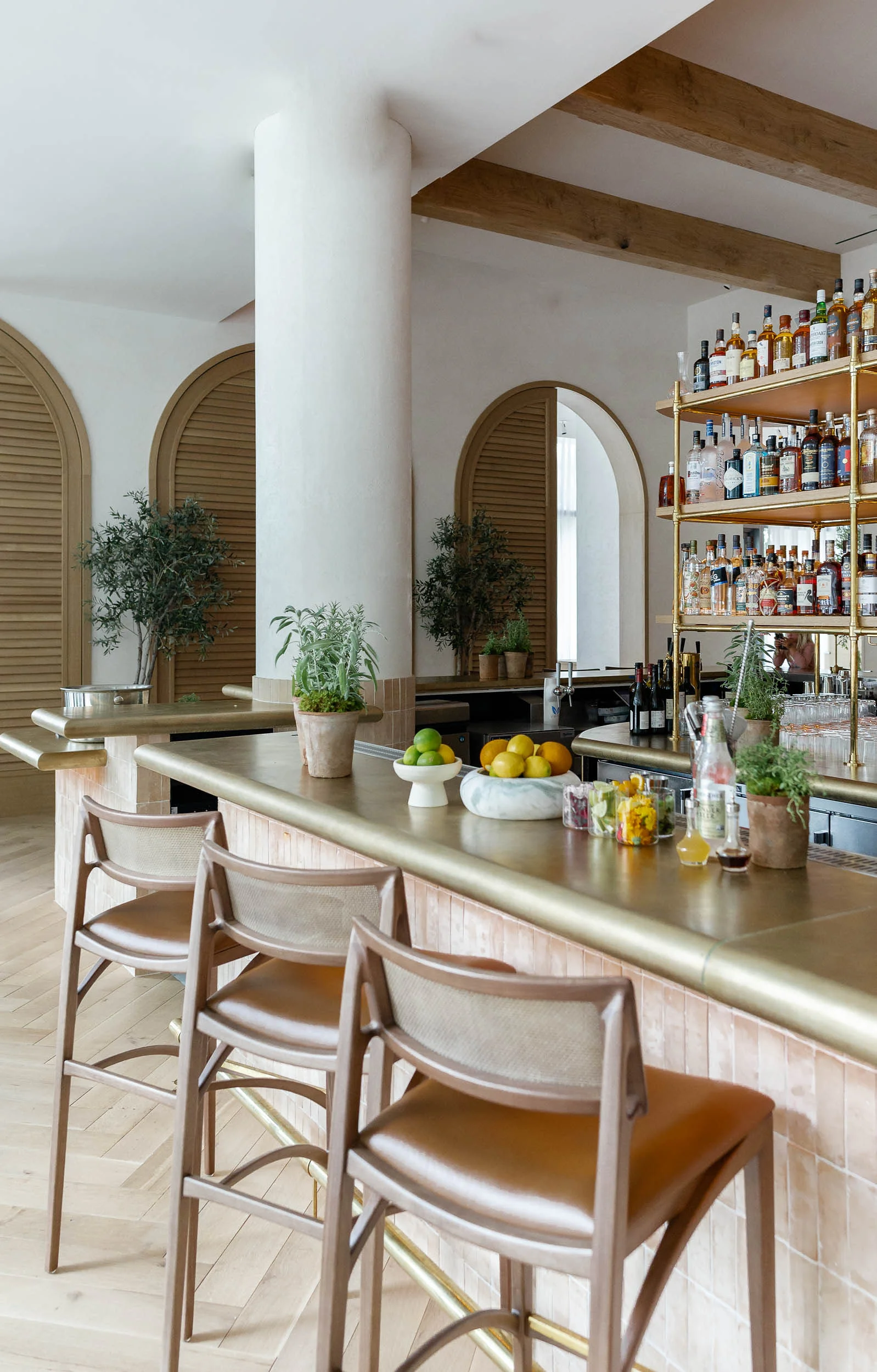 Bright bar with a brass bar top beneath arched doorways